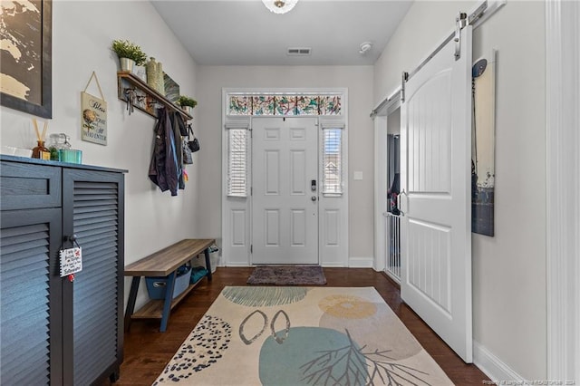 entryway featuring a barn door and dark hardwood / wood-style floors