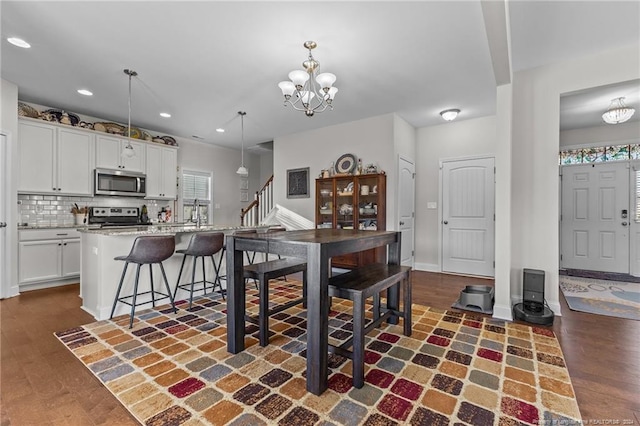 dining area with dark hardwood / wood-style floors and an inviting chandelier