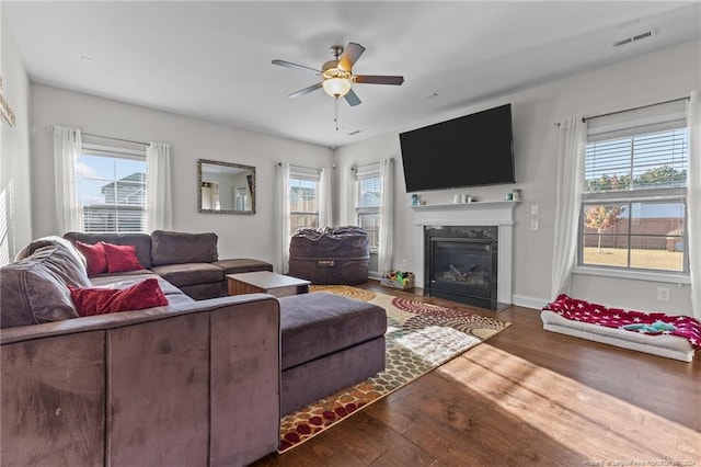 living room featuring a high end fireplace, dark hardwood / wood-style floors, and plenty of natural light