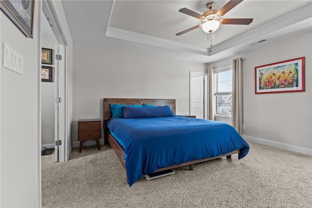 bedroom featuring crown molding, carpet floors, a tray ceiling, and ceiling fan