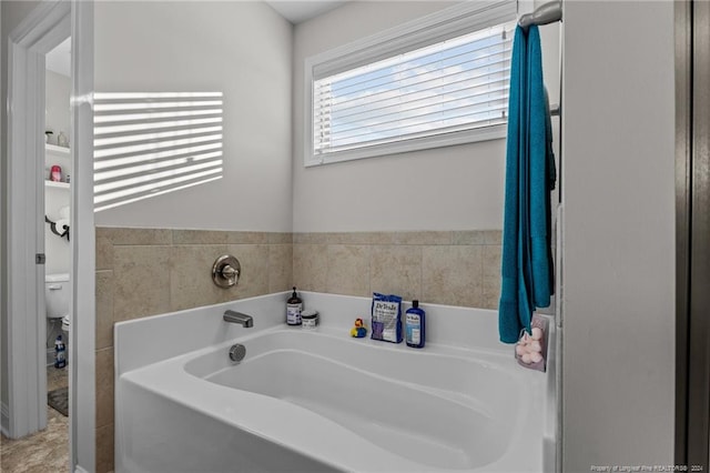 bathroom featuring toilet and a bath