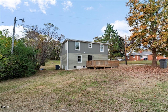 rear view of house with a yard, a deck, and cooling unit