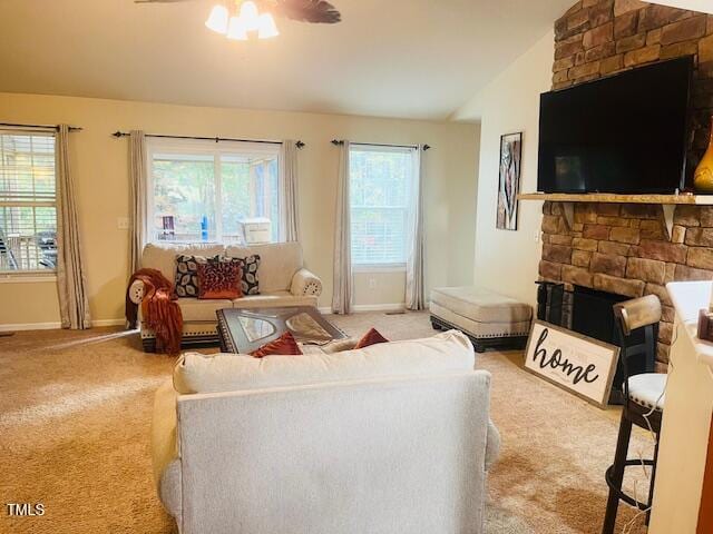 carpeted living room featuring a fireplace, ceiling fan, vaulted ceiling, and a wealth of natural light