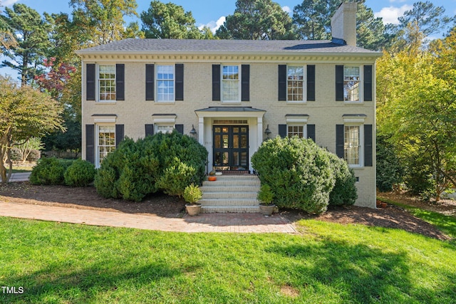 colonial inspired home featuring a front yard