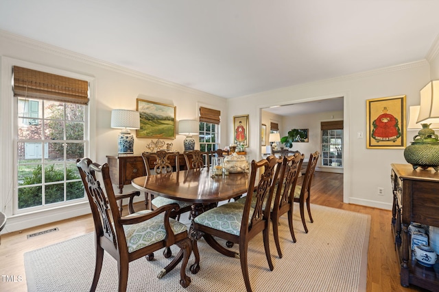 dining area featuring light hardwood / wood-style floors and ornamental molding