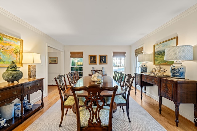 dining space featuring ornamental molding and light hardwood / wood-style flooring