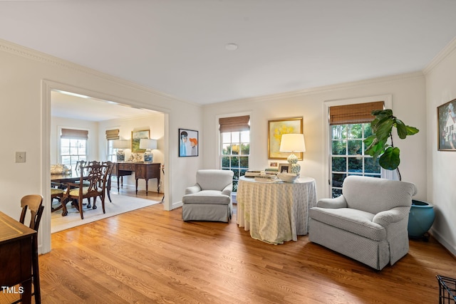 living room with crown molding, a healthy amount of sunlight, and hardwood / wood-style floors