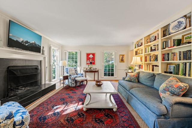 living room with crown molding, hardwood / wood-style floors, and a tiled fireplace