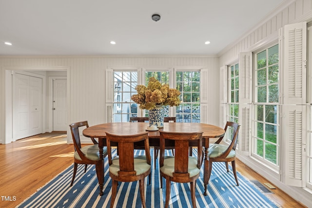 dining space featuring crown molding and wood-type flooring