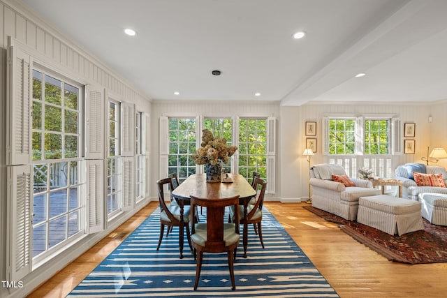 dining area featuring ornamental molding, light wood-type flooring, and a wealth of natural light