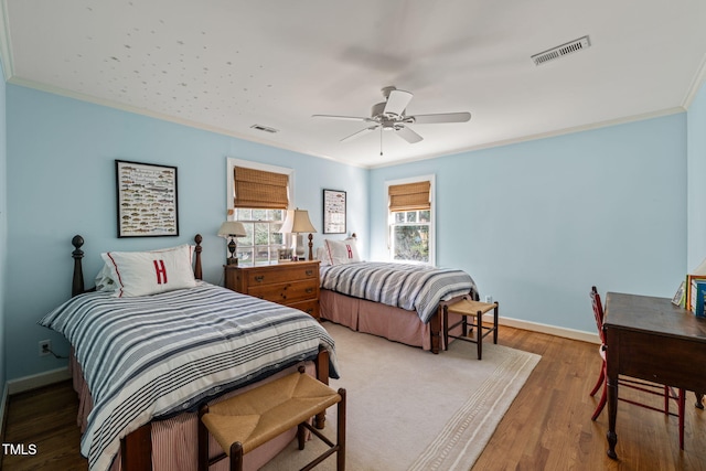 bedroom featuring ornamental molding, wood-type flooring, and ceiling fan