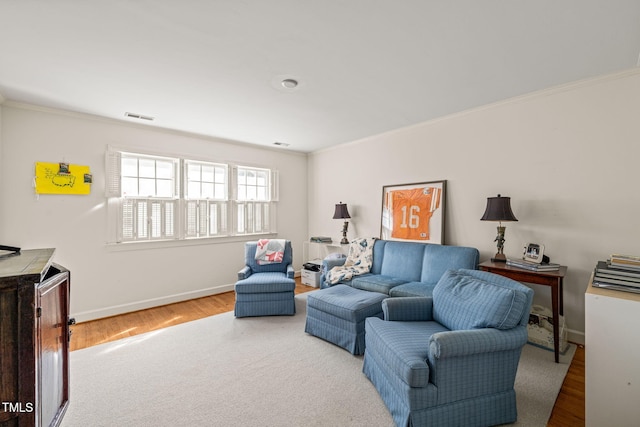 living room with ornamental molding and light hardwood / wood-style flooring