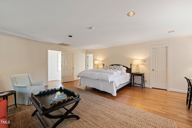 bedroom with crown molding and light hardwood / wood-style flooring