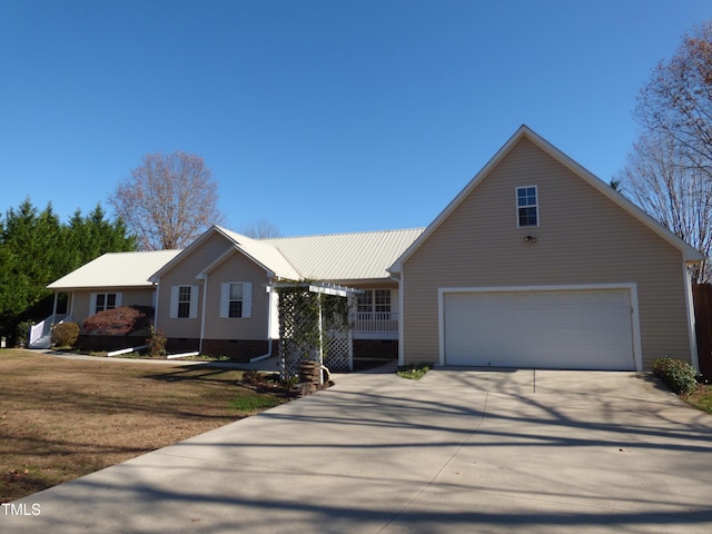 view of front facade featuring a porch, a garage, and a front lawn