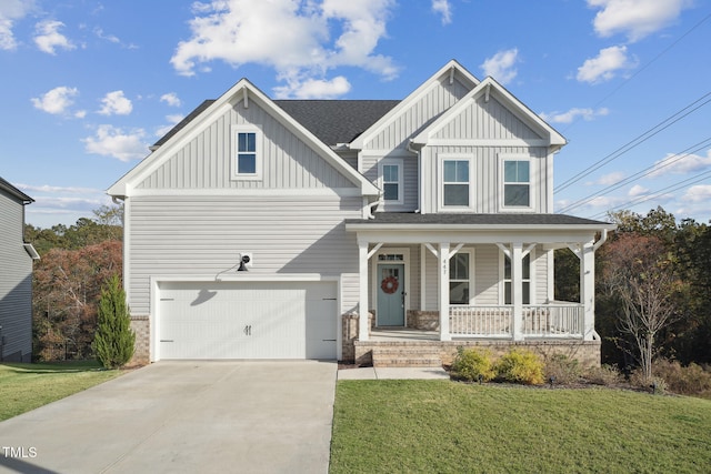 view of front of house featuring a garage, a front yard, and covered porch