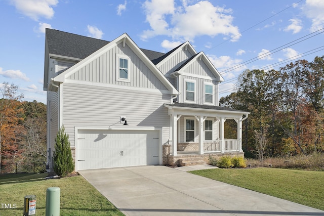 view of front facade with covered porch, a garage, and a front lawn