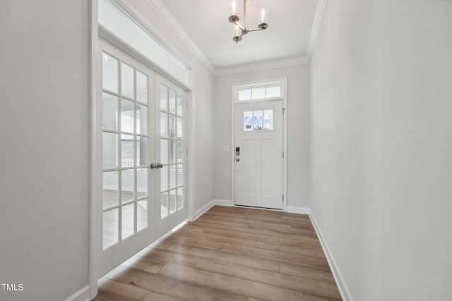 entryway featuring a notable chandelier, light hardwood / wood-style flooring, and ornamental molding