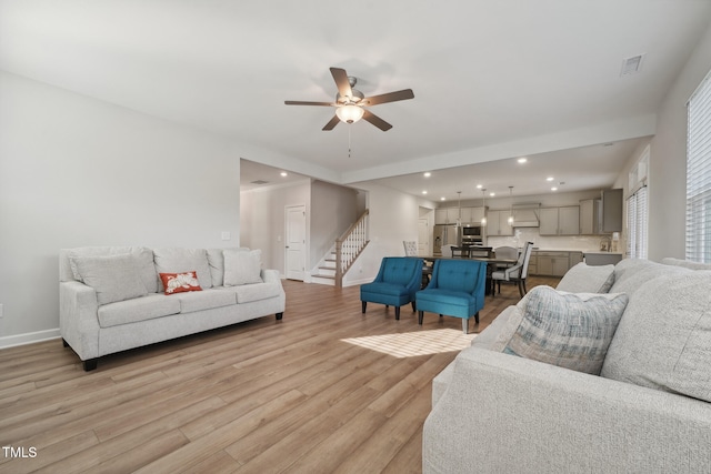 living room with light wood-type flooring and ceiling fan