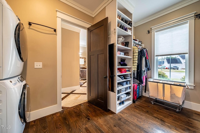 washroom with a healthy amount of sunlight, stacked washer / drying machine, dark wood-type flooring, and ornamental molding