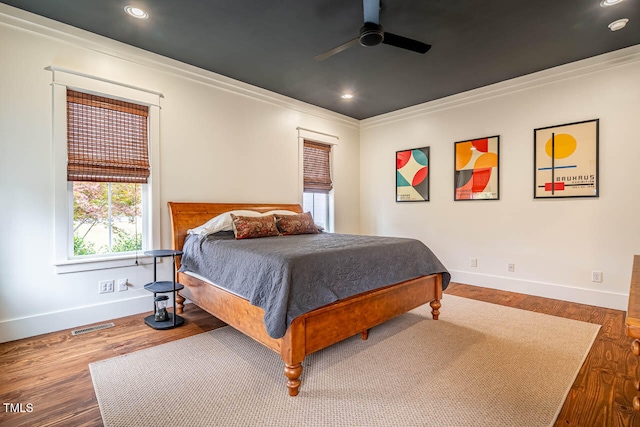 bedroom featuring crown molding, wood-type flooring, and ceiling fan