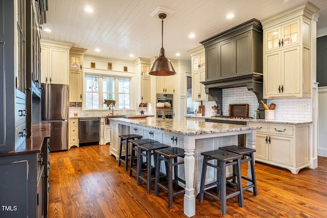 kitchen with stainless steel appliances, a center island, tasteful backsplash, wood-type flooring, and decorative light fixtures