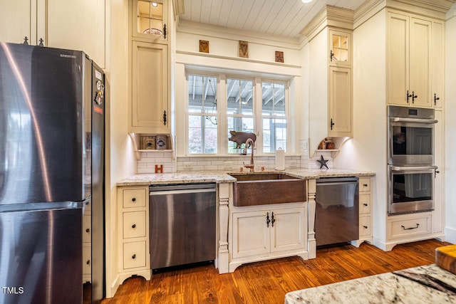 kitchen with stainless steel appliances, dark hardwood / wood-style floors, light stone countertops, and sink