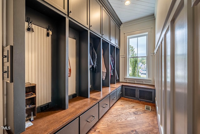 mudroom with radiator, crown molding, and light hardwood / wood-style floors