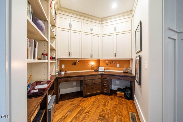 home office with dark hardwood / wood-style floors and built in desk