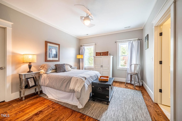 bedroom featuring hardwood / wood-style floors, ornamental molding, and ceiling fan