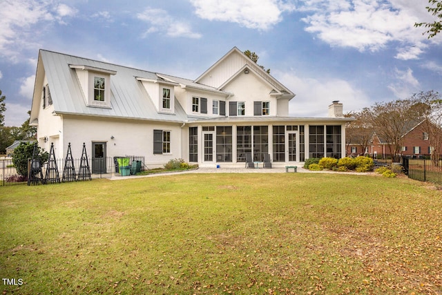 back of house featuring a sunroom and a lawn