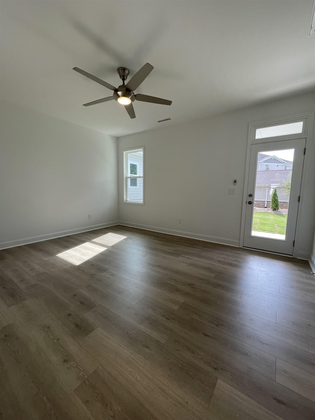 empty room with dark hardwood / wood-style flooring and ceiling fan