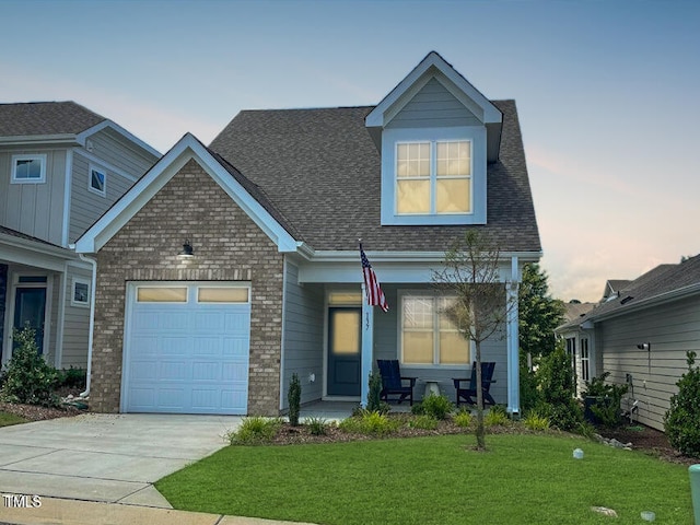 view of front of property with a garage and a yard