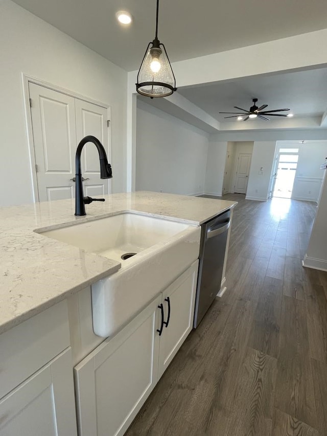 kitchen with white cabinets, light stone countertops, stainless steel dishwasher, dark wood-type flooring, and decorative light fixtures