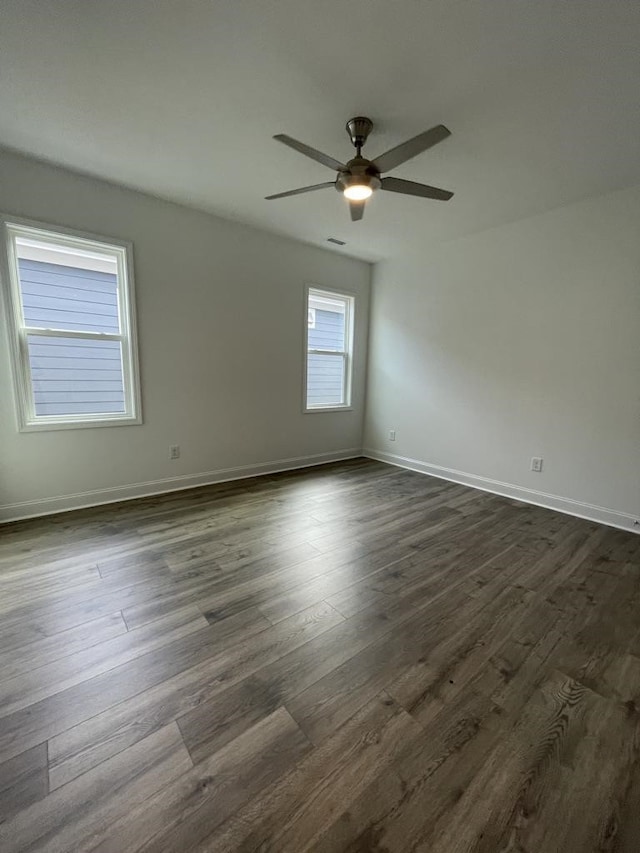 empty room featuring dark wood-type flooring and ceiling fan