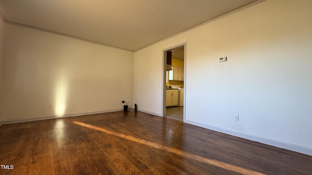 spare room featuring crown molding and dark wood-type flooring