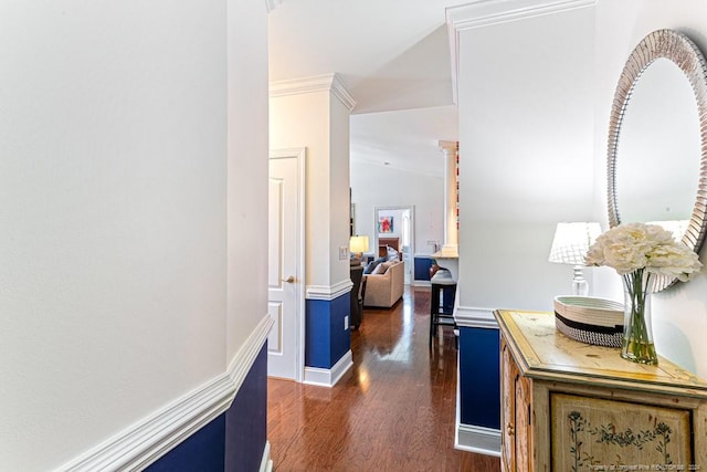 hallway with ornamental molding, vaulted ceiling, and dark hardwood / wood-style flooring