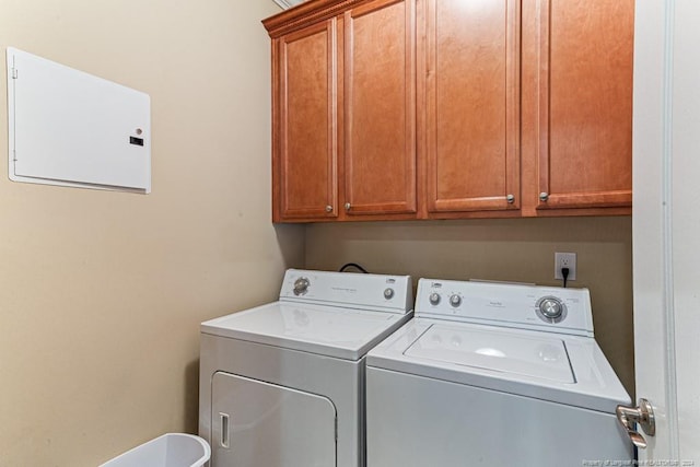 laundry area with electric panel, cabinets, and washing machine and clothes dryer