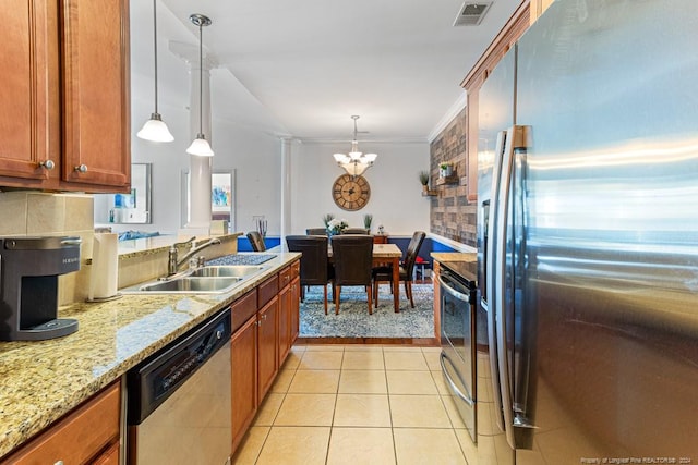 kitchen featuring sink, crown molding, hanging light fixtures, and stainless steel appliances