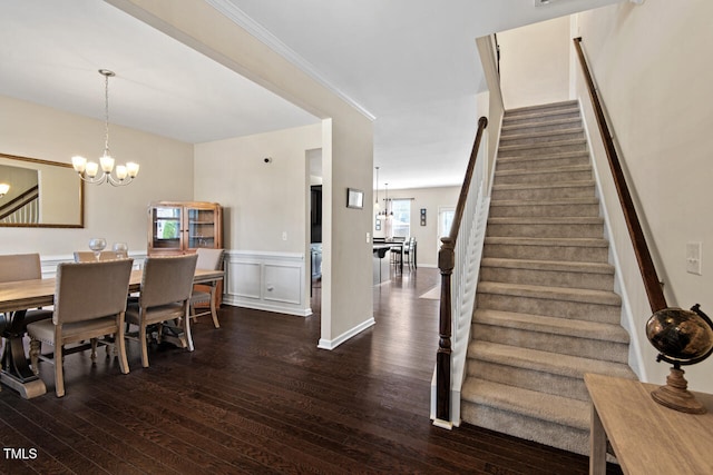 dining space with ornamental molding, a healthy amount of sunlight, dark hardwood / wood-style floors, and an inviting chandelier