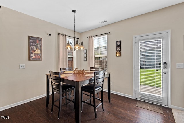 dining space featuring dark hardwood / wood-style flooring and a notable chandelier