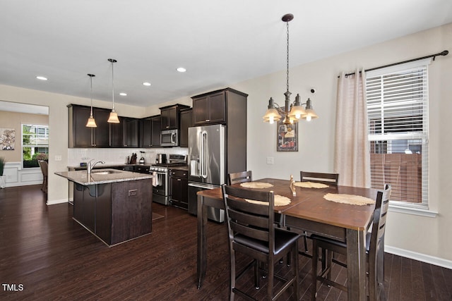 dining room with dark wood-type flooring, a chandelier, and sink