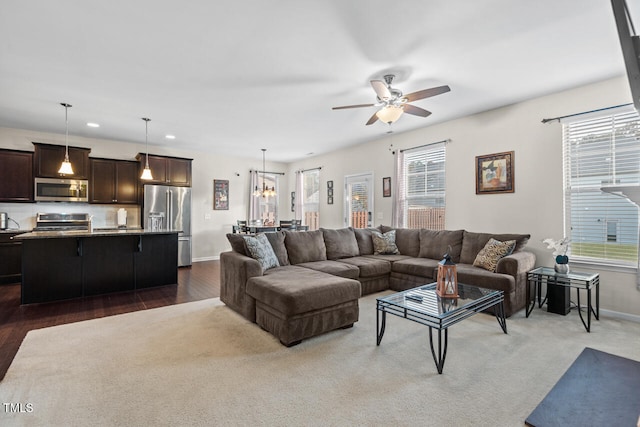 living room featuring dark hardwood / wood-style floors and ceiling fan with notable chandelier