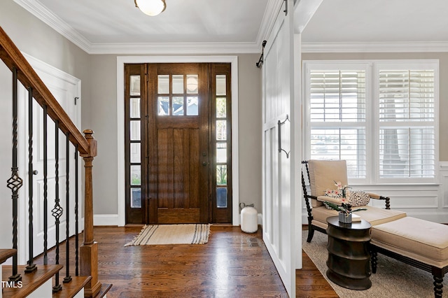 foyer entrance featuring ornamental molding, dark hardwood / wood-style flooring, and a barn door