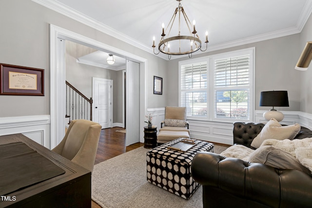 living room with ornamental molding, stairs, dark wood-style floors, a wainscoted wall, and a chandelier