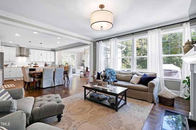 living area featuring ornamental molding, dark wood-type flooring, recessed lighting, and a chandelier