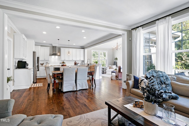 living room with crown molding, recessed lighting, dark wood-style flooring, and a notable chandelier