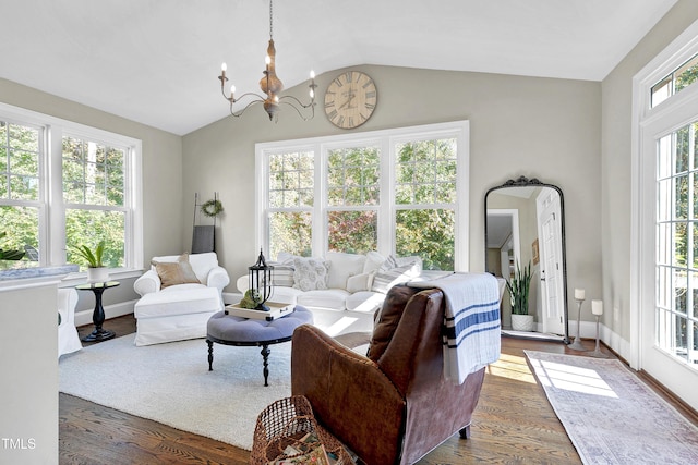 living area with an inviting chandelier, baseboards, vaulted ceiling, and wood finished floors