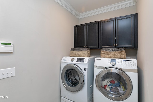 washroom with cabinets, crown molding, and washing machine and dryer