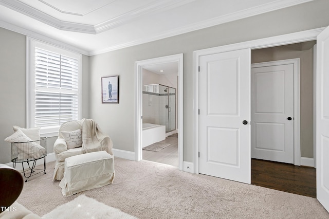 sitting room with carpet floors, ornamental molding, baseboards, and a tray ceiling