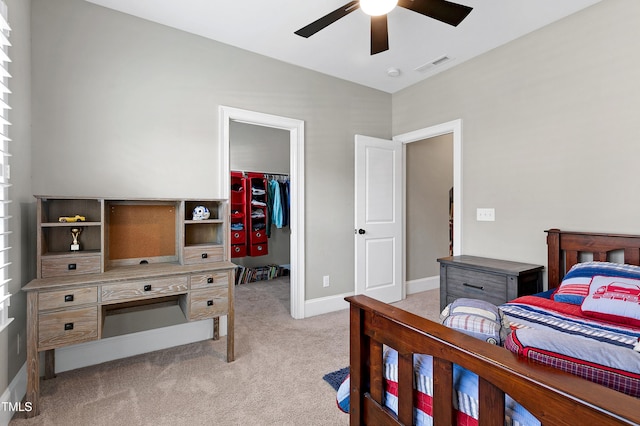 bedroom featuring a ceiling fan, light colored carpet, visible vents, a closet, and a spacious closet